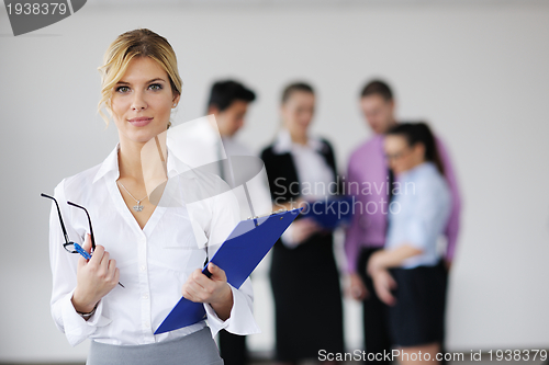 Image of business woman standing with her staff in background