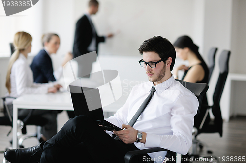 Image of Portrait of a handsome young business man with colleagues in bac