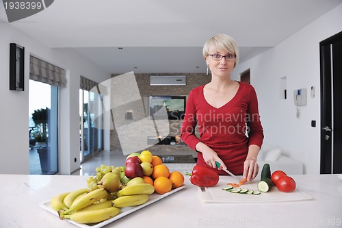 Image of happy  beautiful blonde  woman prepare food in  the kitchen
