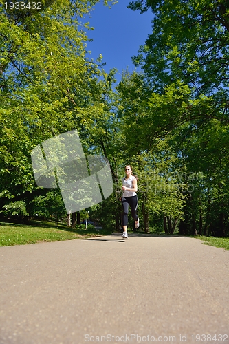 Image of Young beautiful  woman jogging at morning in park