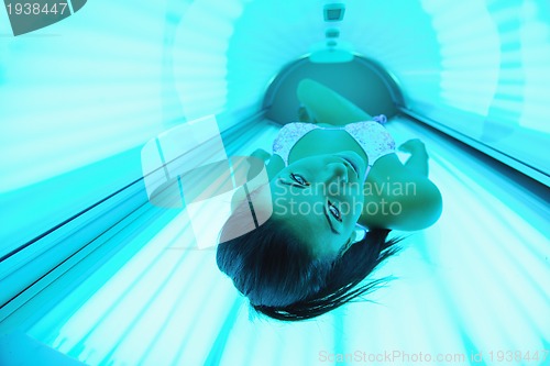 Image of Beautiful young woman tanning in solarium