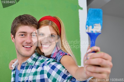 Image of happy couple paint wall at new home