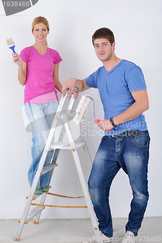 Image of happy couple paint wall at new home