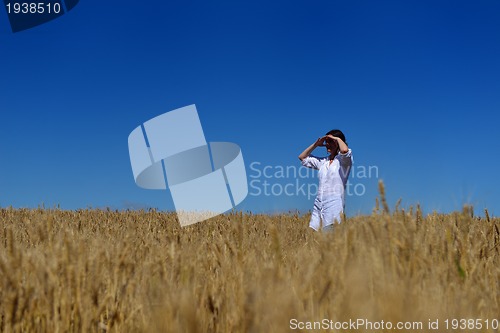 Image of young woman in wheat field at summer