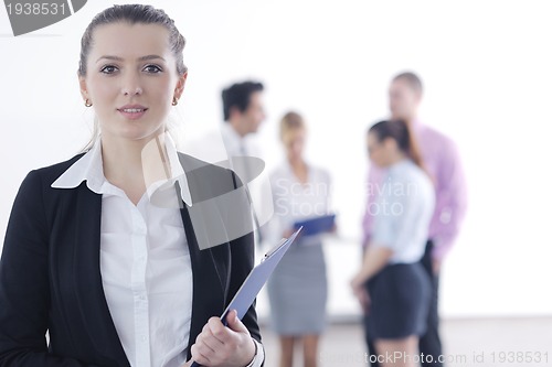 Image of business woman standing with her staff in background