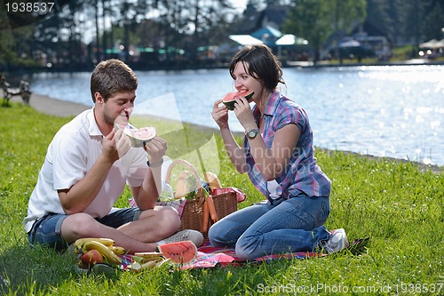 Image of happy young couple having a picnic outdoor