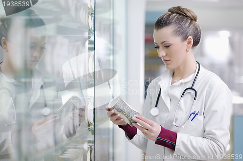 Image of pharmacist chemist woman standing in pharmacy drugstore