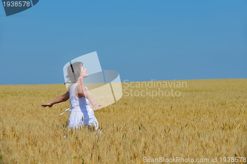 Image of young woman in wheat field at summer
