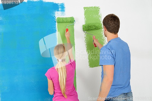 Image of happy couple paint wall at new home
