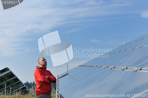 Image of engineer using laptop at solar panels plant field