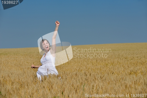 Image of young woman in wheat field at summer