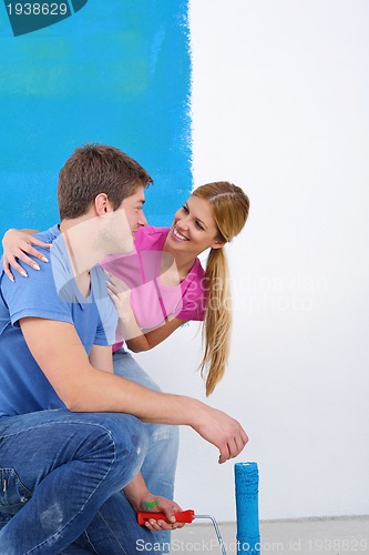 Image of happy couple paint wall at new home