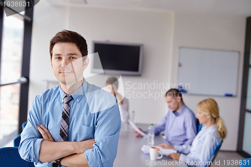 Image of business man  on a meeting in offce with colleagues in backgroun