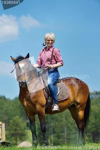 Image of happy woman  ride  horse