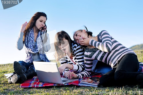 Image of group of teens working on laptop outdoor