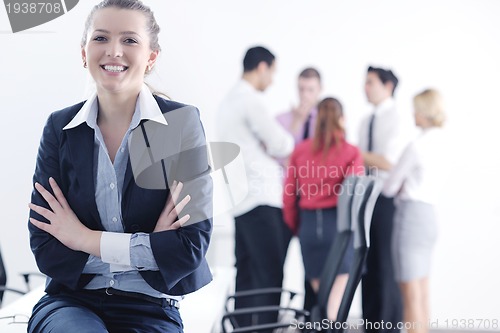Image of business woman standing with her staff in background