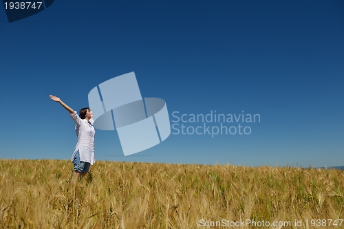 Image of young woman in wheat field at summer