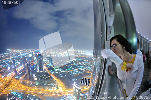 Image of beautiful woman portrait with big city at night in background