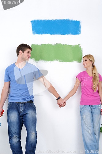 Image of happy couple paint wall at new home