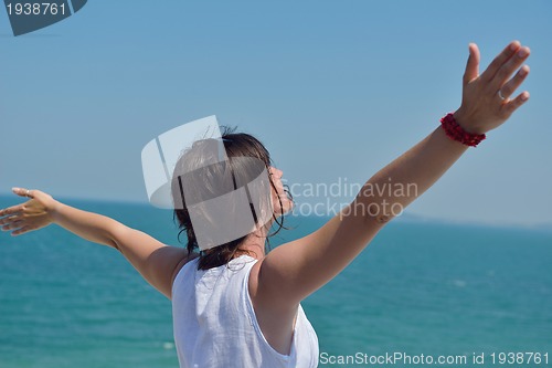 Image of happy young woman with spreading arms to sky