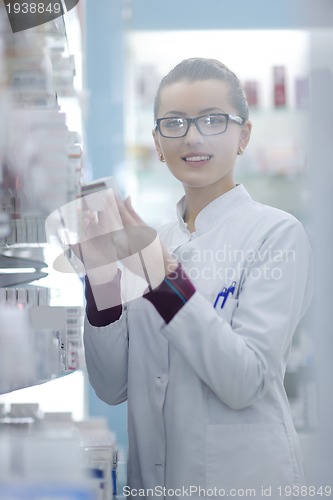 Image of pharmacist chemist woman standing in pharmacy drugstore