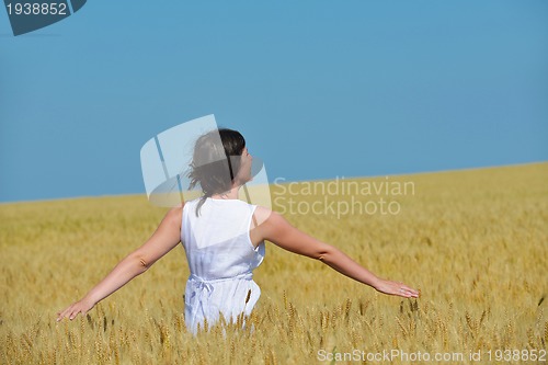 Image of young woman in wheat field at summer