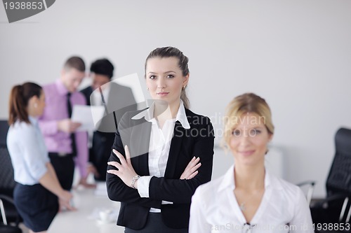 Image of business woman standing with her staff in background