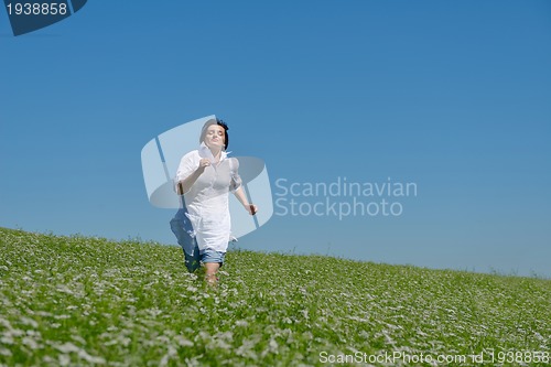 Image of Young happy woman in green field