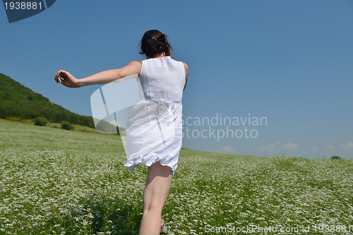 Image of Young happy woman in green field