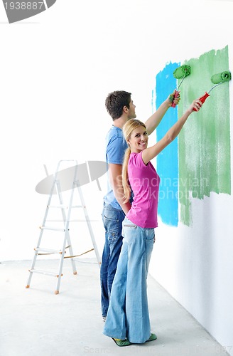 Image of happy couple paint wall at new home