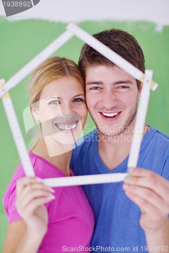 Image of happy couple paint wall at new home