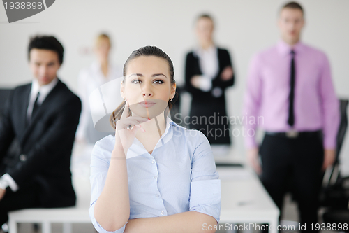 Image of business woman standing with her staff in background