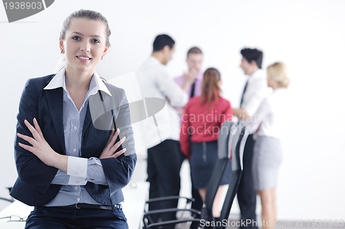 Image of business woman standing with her staff in background