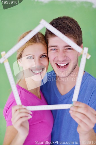 Image of happy couple paint wall at new home