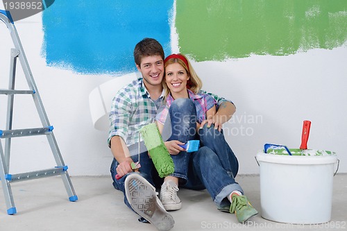 Image of happy young cople relaxing after painting in new home