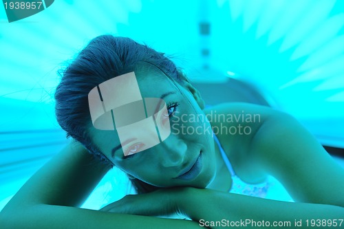 Image of Beautiful young woman tanning in solarium