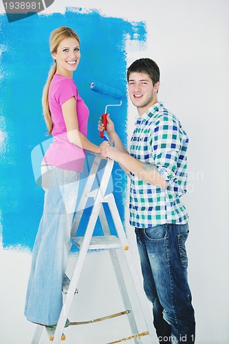 Image of happy couple paint wall at new home