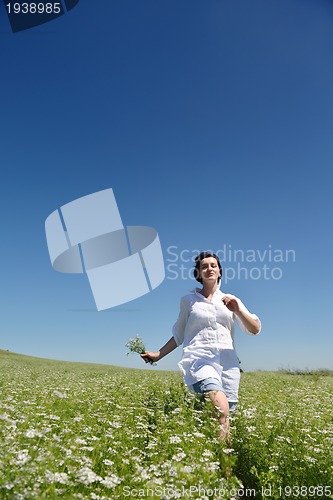 Image of Young happy woman in green field