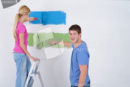 Image of happy couple paint wall at new home