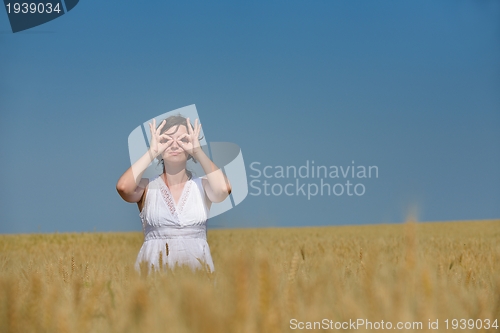 Image of young woman in wheat field at summer