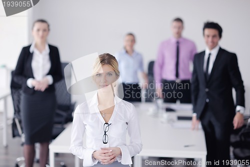 Image of business woman standing with her staff in background