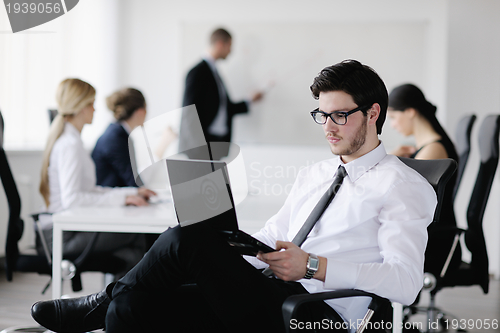 Image of Portrait of a handsome young business man with colleagues in bac