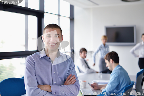 Image of business man  on a meeting in offce with colleagues in backgroun