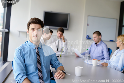 Image of business man  on a meeting in offce with colleagues in backgroun