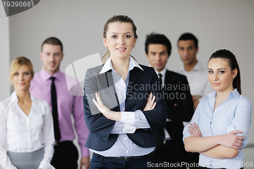 Image of business woman standing with her staff in background