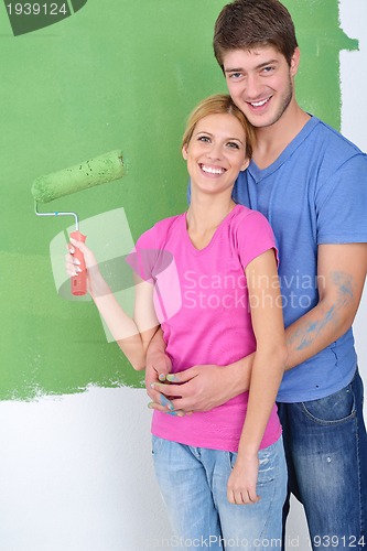 Image of happy couple paint wall at new home