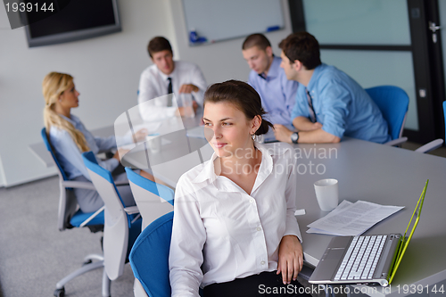 Image of business woman with her staff in background at office