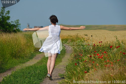 Image of young woman in wheat field at summer