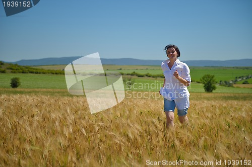 Image of young woman in wheat field at summer