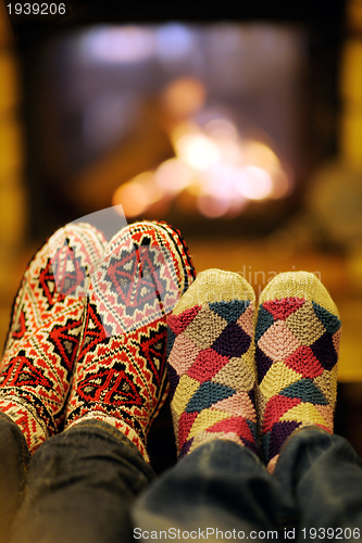 Image of Young romantic couple relax on sofa in front of fireplace at hom